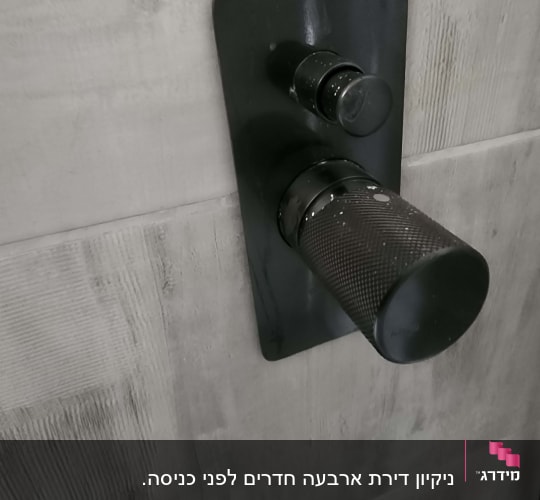 ברז מקלחת עם כתמי מים על הקיר